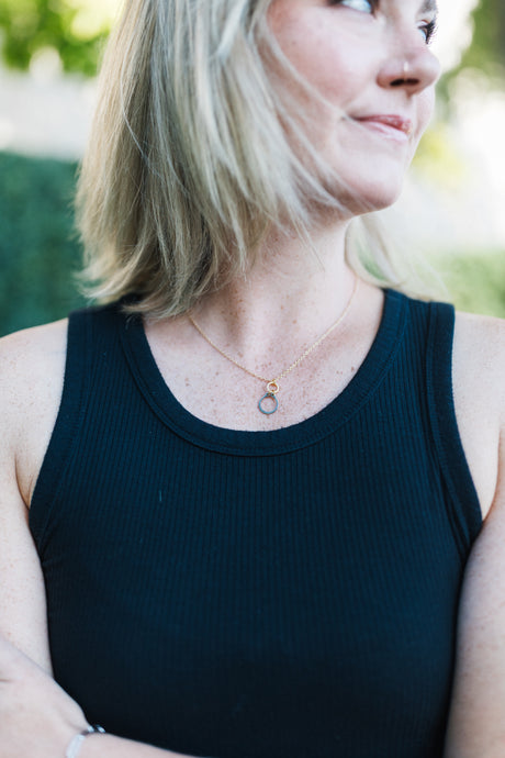 Woman wearing a black tank top with a silver and black necklace for sale by Mend on the Move