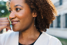 Load image into Gallery viewer, Woman with a smile, wearing black and silver earrings for sale by Mend on the Move 