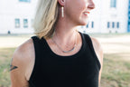 Person wearing a black tank top with silver necklace for sale by Mend on the Move