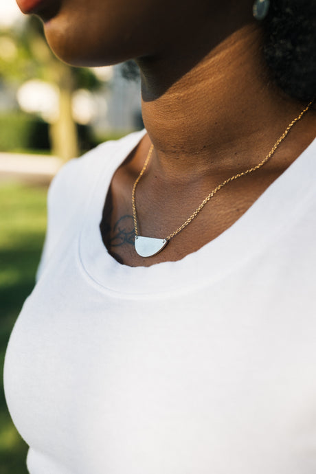 Person wearing a silver necklace with a gold plated chain for sale by Mend on the Move