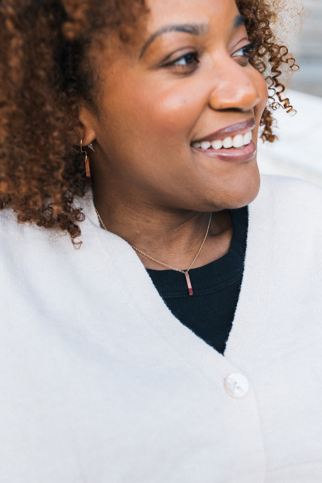 Woman wearing a white sweater with a blurred background, wearing a copper necklace with gold plated chain for sale by Mend on the Move
