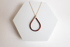 Teardrop-shaped copper pendant necklace for sale by Mend on the Move on a white hexagonal stand