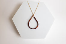 Load image into Gallery viewer, Teardrop-shaped copper pendant necklace for sale by Mend on the Move on a white hexagonal stand