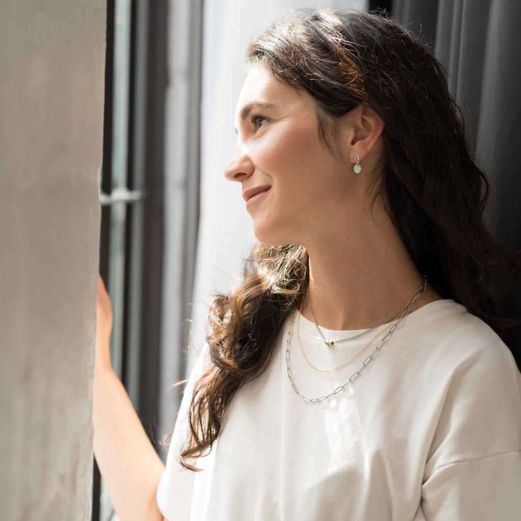 three strand necklace woman looking out window