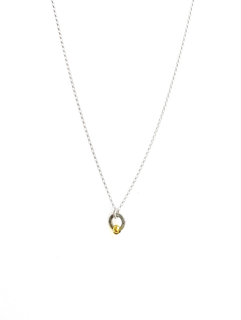 A sterling silver necklace with a small silver charm and gold bead shaped like a seed, on a white background.